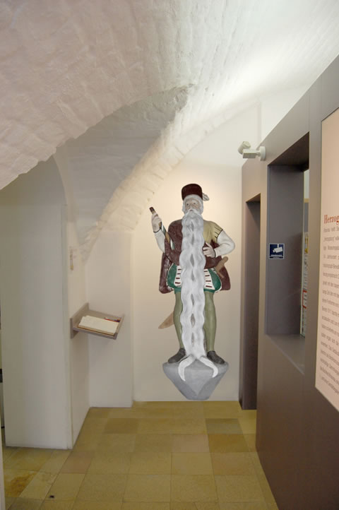 Fotomontage überlebensgroße Hans Staininger Figur im Eingangsbereich der Herzogsburg